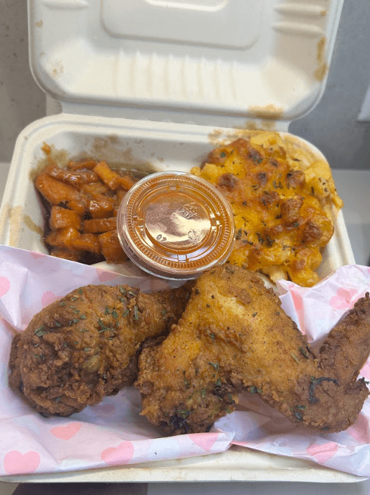 Fried chicken with mac and cheese, candied yams, and sauce—soul food catering plate